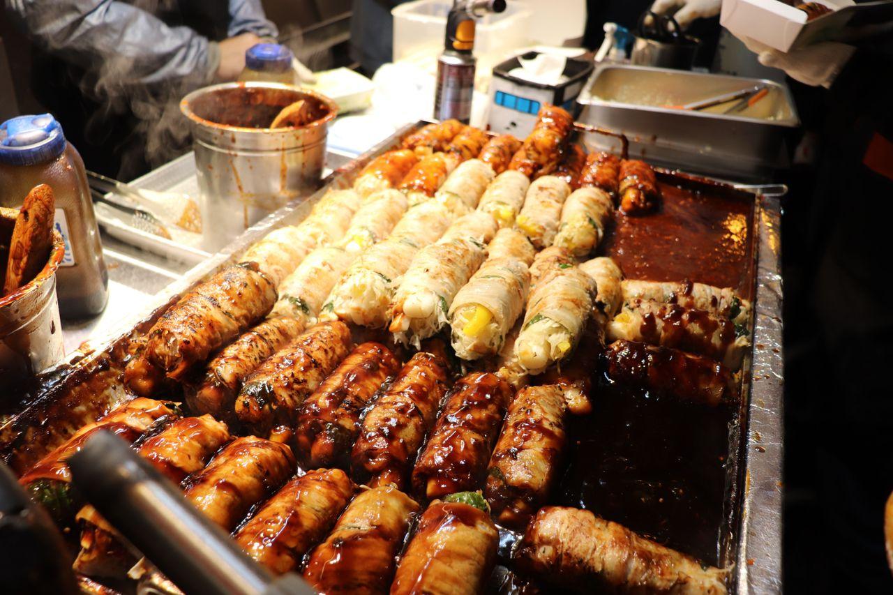 富平市場的攤位上展示著琳琅滿目的美味小吃和各色新奇商品